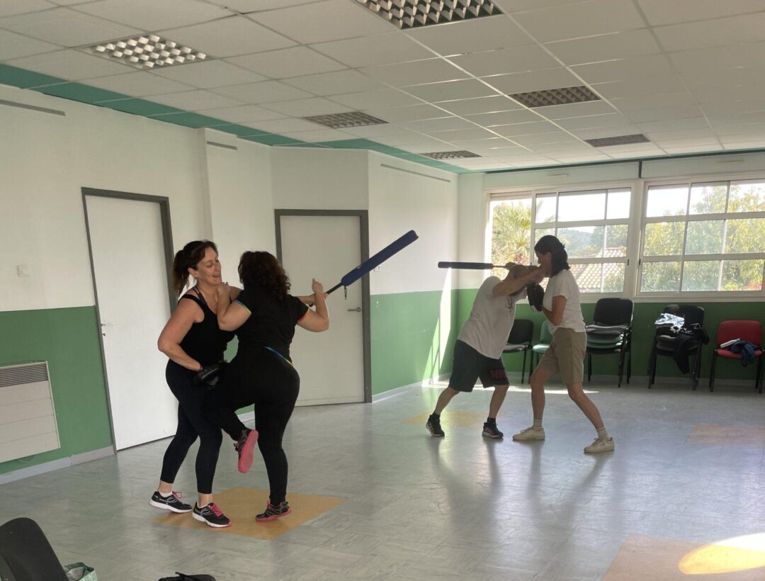 Adultes en train de s'entrainer à des techniques de self défense. Apprendre à se défendre contre attaque au baton